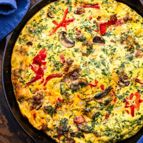 Sausage, mushroom, and roasted red pepper frittata in cast iron pan.