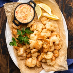 Fried shrimp in white platter with Calabrian dipping sauce.