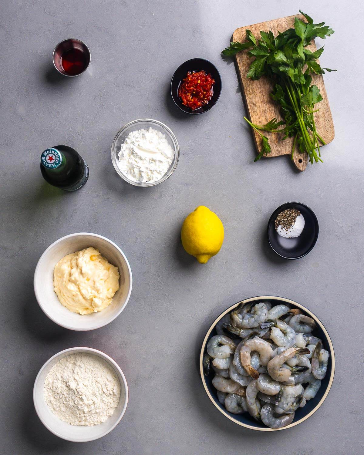 Ingredients shown: red wine vinegar, Calabrian chili paste, parsley, lager beer, cornstarch, mayonnaise, lemon, salt, pepper, flour, and raw shrimp.