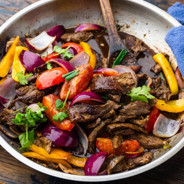 Large pan with lomo saltado topped with cilantro.