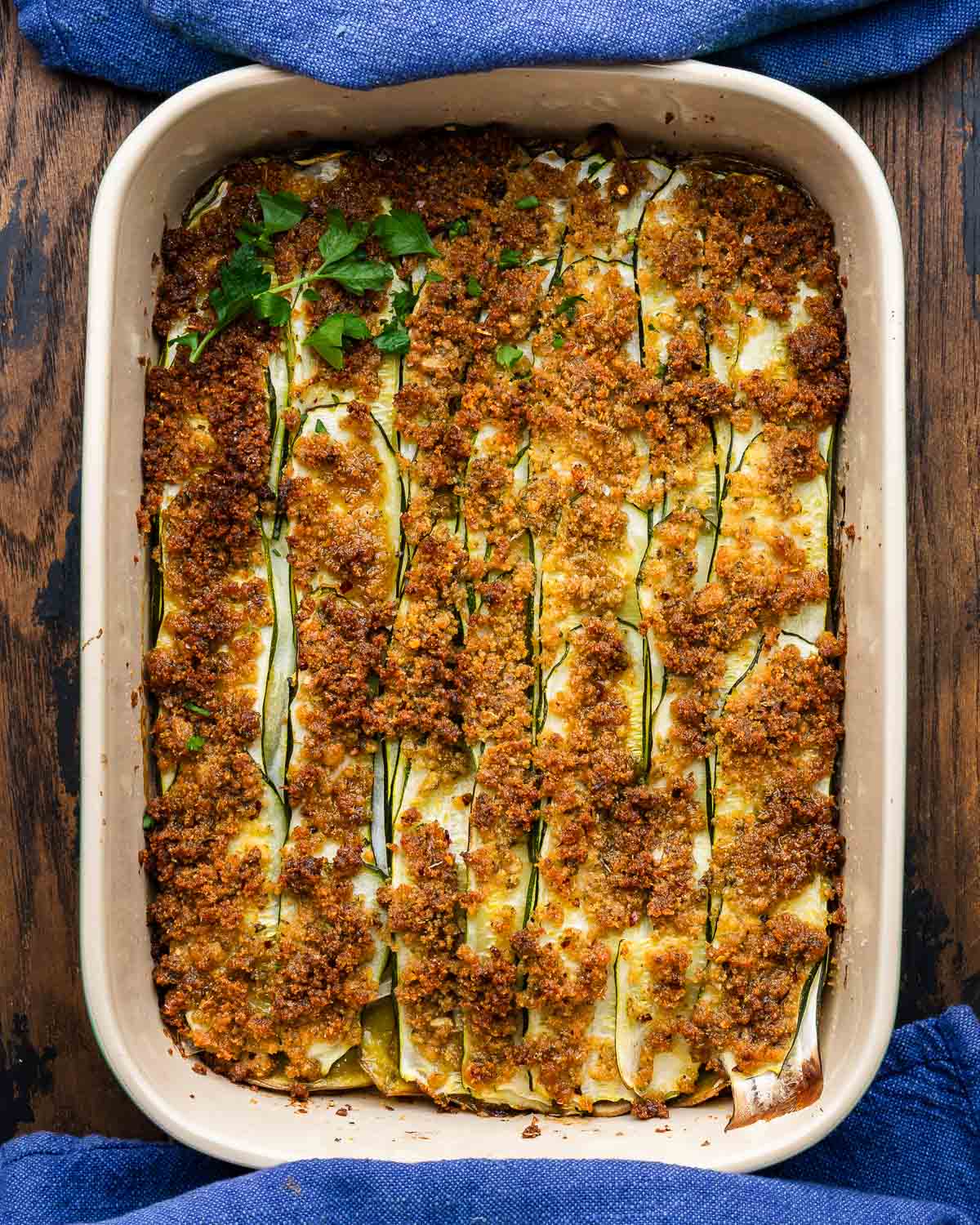 Overhead shot of zucchini potato al forno topped with parsley garnish.