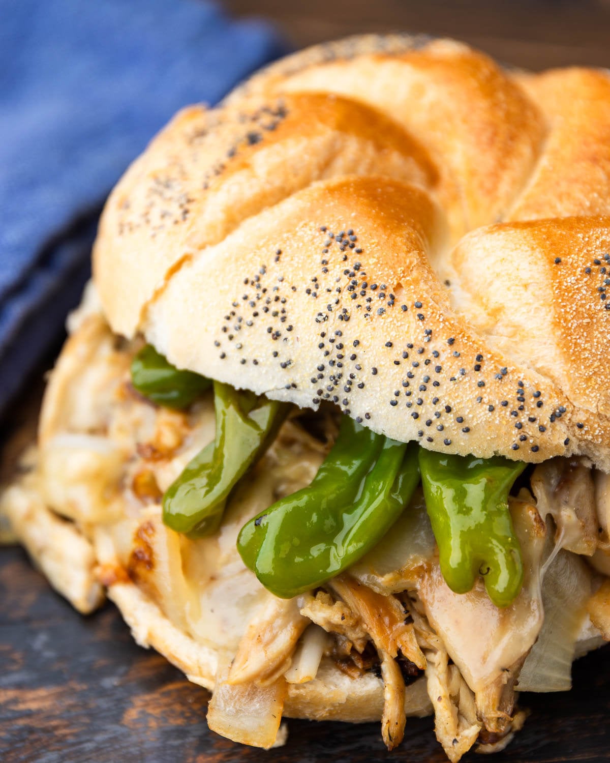 Chicken cheeseteak with shishito peppers on a roll.