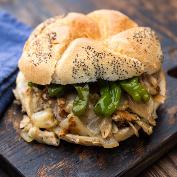 Chicken cheeseteak with shishito peppers on a hard roll.