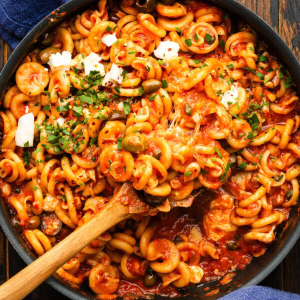 Spoon scooping the pasta vesuviana out of the pan.