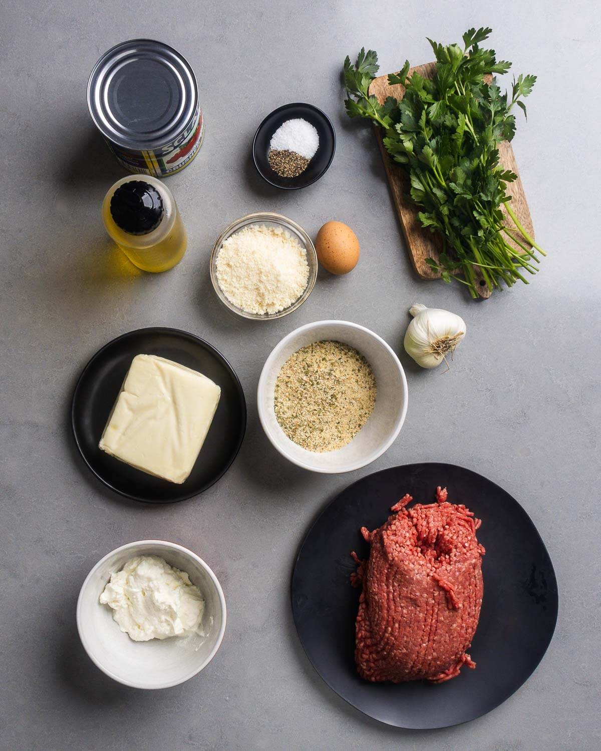 Ingredients shown: canned tomatoes, olive oil, salt, pepper, parmesan, egg, parsley, garlic, mozzarella, breadcrumbs, ricotta, and ground sirloin.