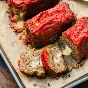 Mini stuffed meatloaf cut open showing the melty cheese.