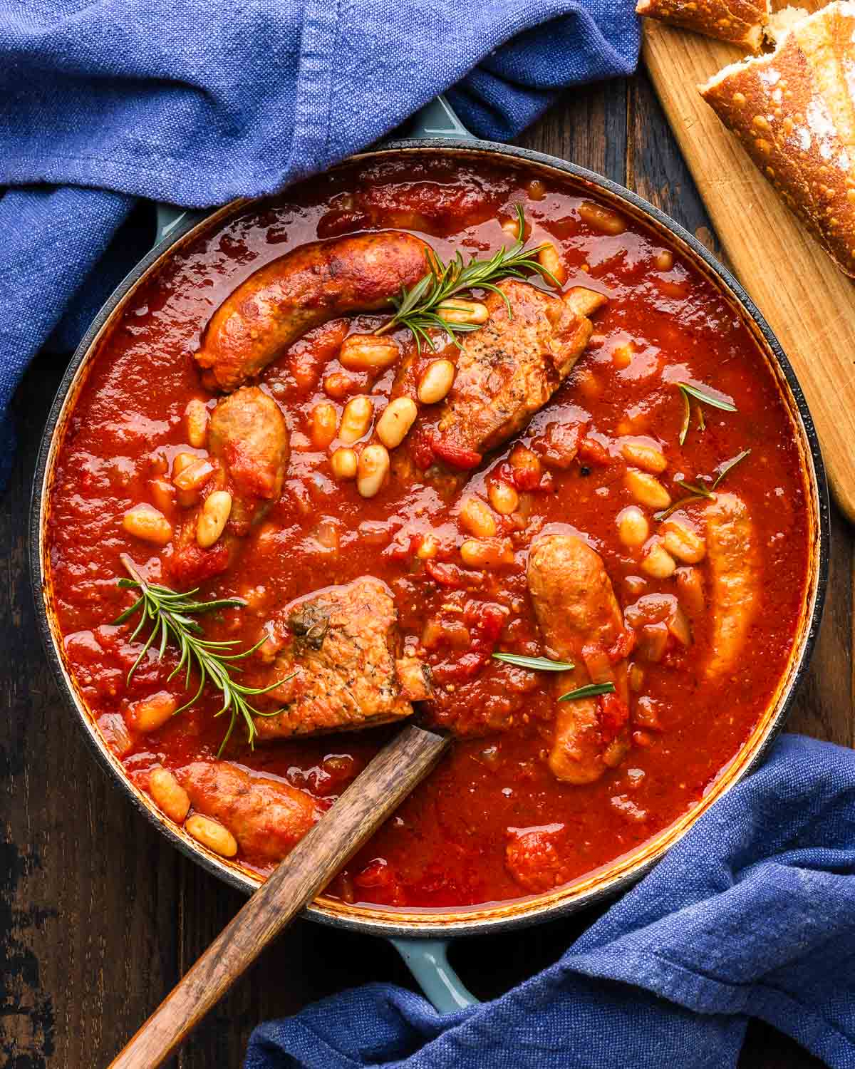Large pot with braised sausage, ribs, and cannellini beans.