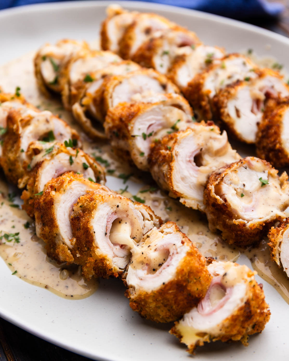 Chicken cordon bleu on white platter.
