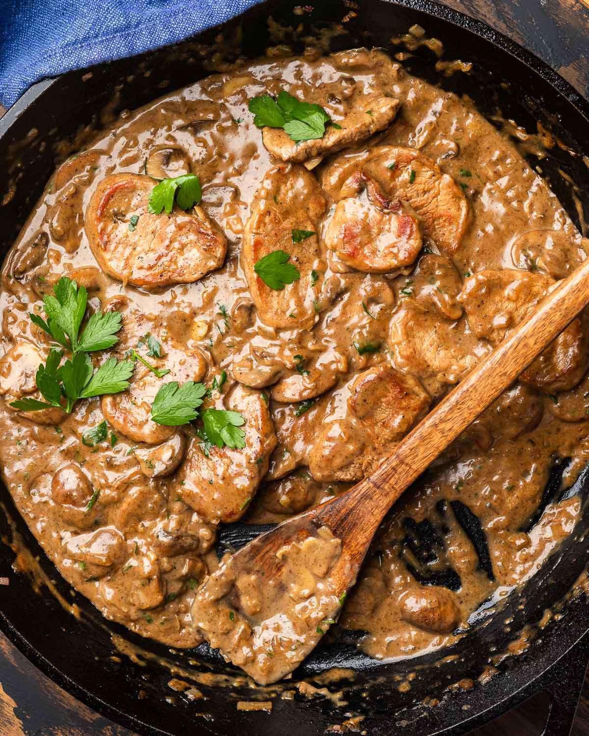 Cast iron pan with creamy pork tenderloin with mushrooms.