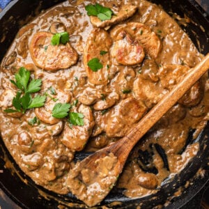 Large pan with creamy pork tenderloin with mushrooms.