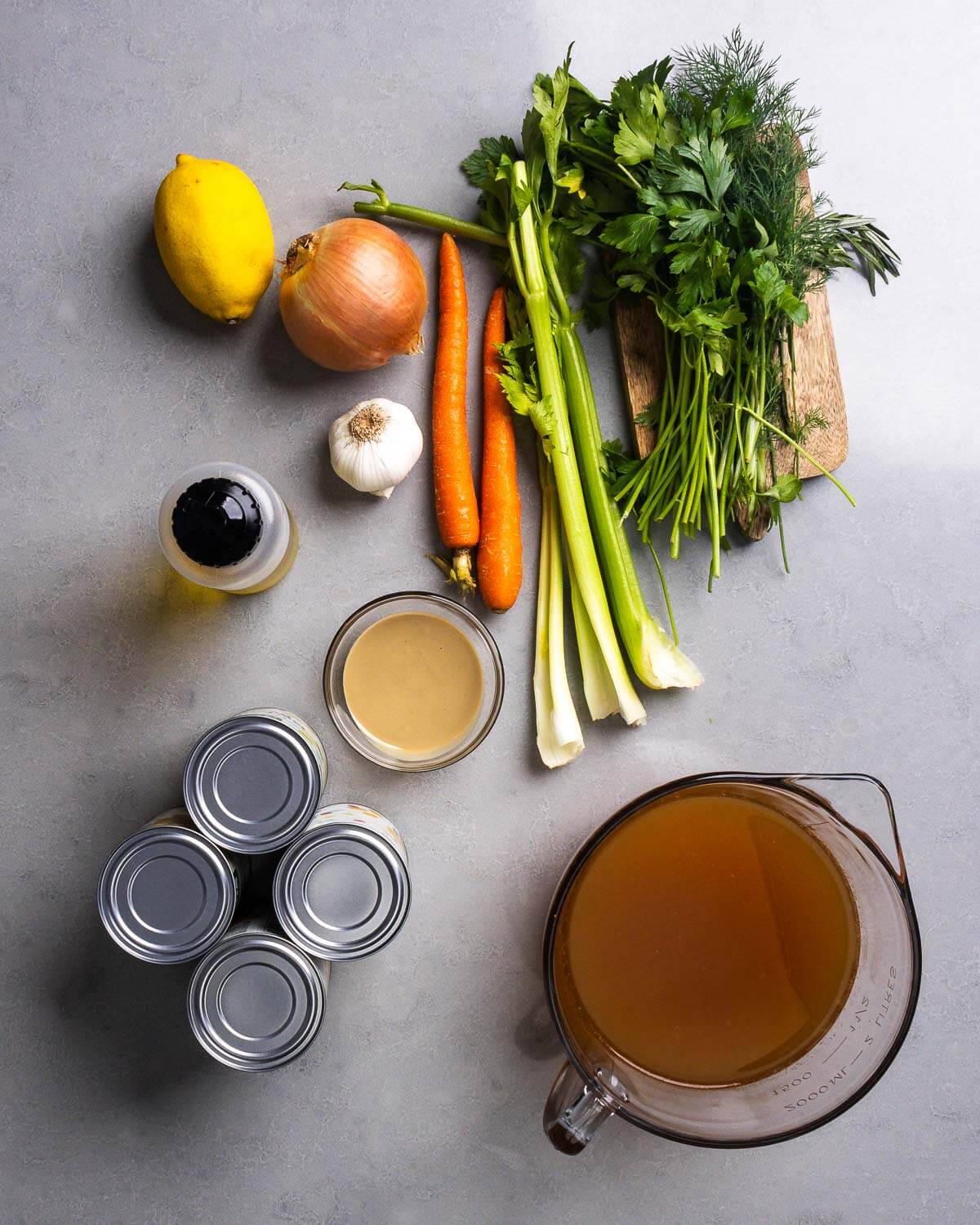 Ingredients shwon: lemon, onion, garlic, olive oil, carrots, celery, parsley, dill, tahini, chickpeas, and vegetable stock.