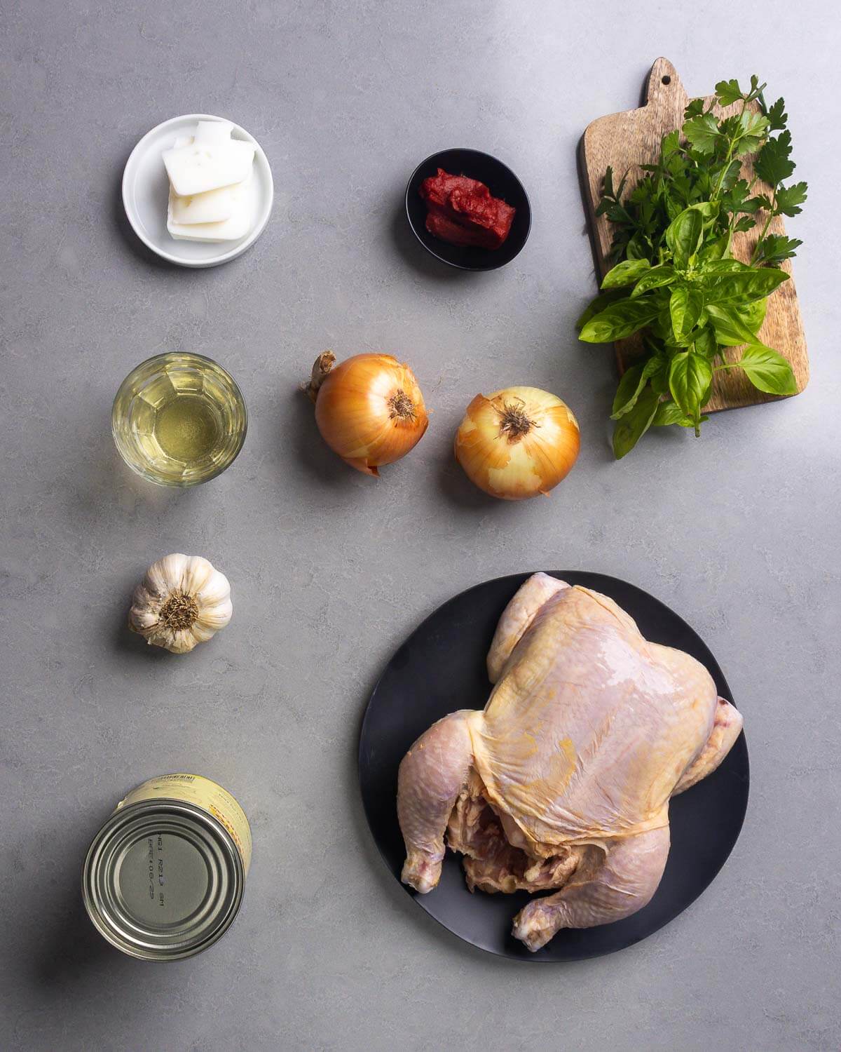 Ingredients shown: lard, tomato paste, basil, parsley, white wine, onions, garlic, plum tomatoes, and a whole chicken.