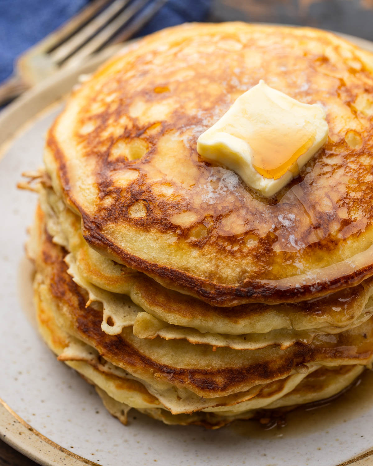 Large stack of buttermilk pancakes on plate.
