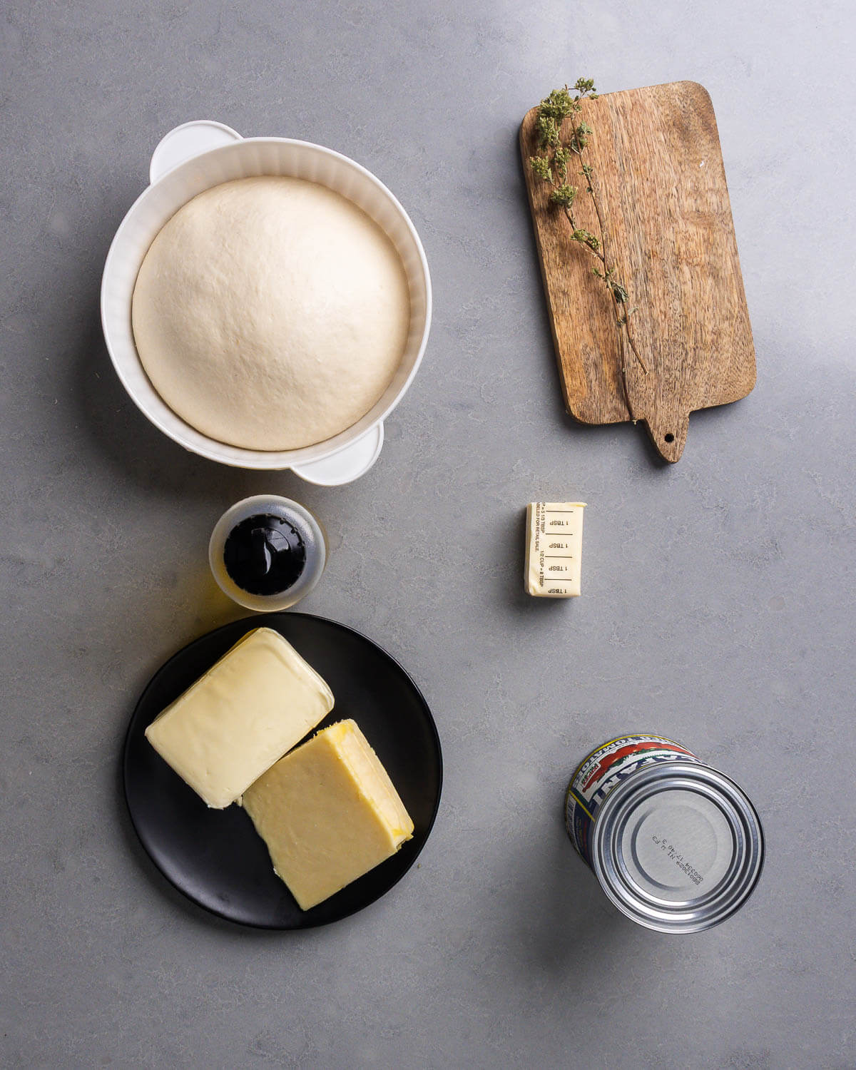 Ingredients shown: dough ball, Sicilian oregano, corn oil, mozzarella cheese, cheddar cheese, buter, and canned tomatoes.